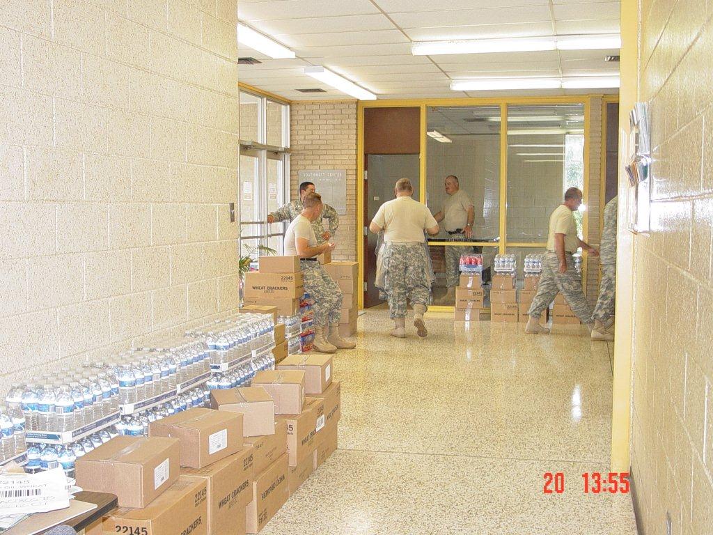 Military personnel set up water and food for the shelter.